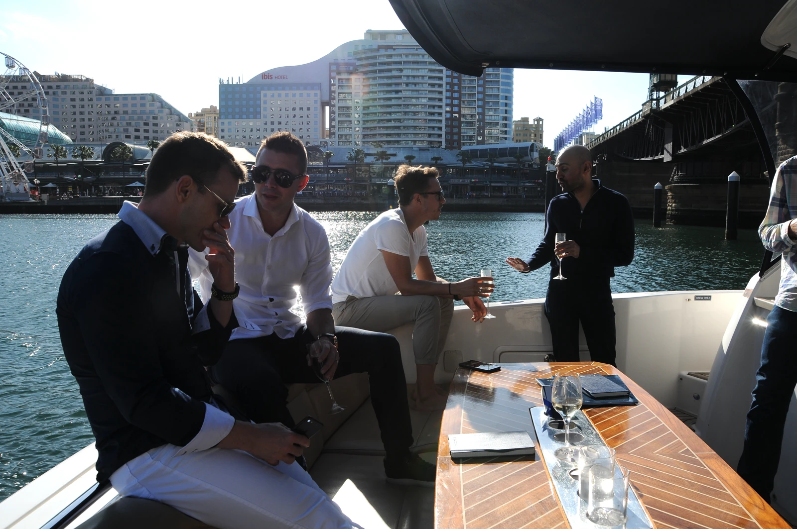 Aaron and Neil Patel socialising with friends on Sydney Harbour